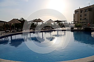 Swimming pool on a background of a sunset, the resort at the Dead Sea, Jordan