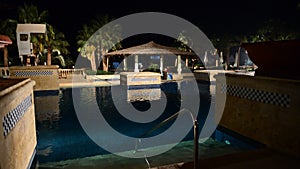 The swimming pool and bar in night illumination at luxury hotel