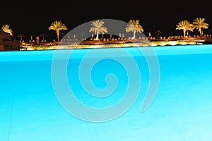The swimming pool and beach at luxury hotel in night illumination