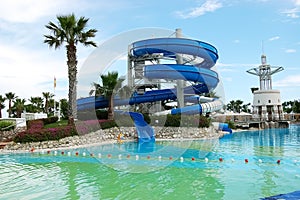 Swimming pool and blue spiral water slide in a hotel, Turkey