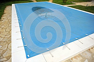 Swimming pool with a blue tarp for protection in winter