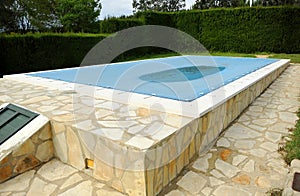 Swimming pool with a blue tarp for protection in winter