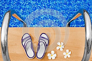 Swimming pool blue water, white plumeria frangipani flowers, women flip flops, poolside, tropical sea beach nature, summer holiday