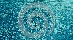 Swimming pool bottom with ripple and flow with waves background. Reflection blue wave water from raining on the outdoor swimming