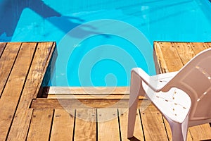 Swimming pool chair on wooden deck floor summer sunny back yard outskirts villa exterior outdoor space without people, copy space