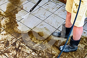 Swimming pool cleaning. A service man is cleaning the pool ground with a high-pressure washer.