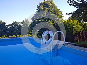 Swimming pool with clear blue water and trees in background