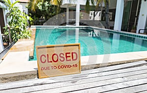 Swimming pool closed sign on poolside, close pool due to covid-19