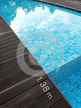 Swimming pool & dark wood deck, depth marking