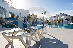 swimming pool with empty sun loungers