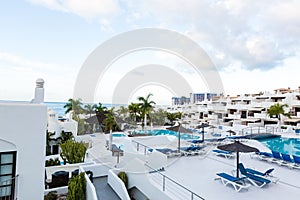 swimming pool with empty sun loungers