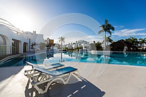 swimming pool with empty sun loungers