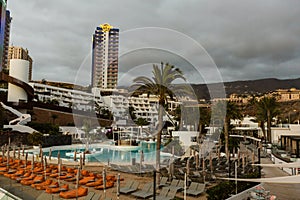 swimming pool with empty sun loungers