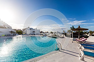 swimming pool with empty sun loungers