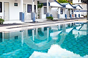 Swimming pool with hotel reflection in a tropical resort. Rest and relaxation