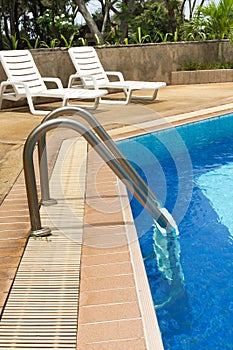 Swimming pool ladder and sunloungers