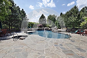 Swimming pool with large stone patio photo