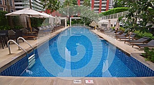 Swimming pool in Luxury Condominium with sundeck chairs