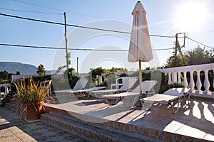 Swimming pool of luxury holiday villa, amazing nature. Relax near swimming pool with handrail, deck chairs, sun loungers.