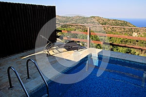 Swimming pool of luxury holiday villa, amazing nature view landscape sea. Relax near swimming pool with handrail, deck chairs.