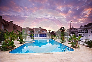 Swimming pool by the luxury resort hotel buildings