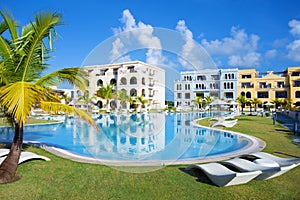 Swimming pool by the luxury resort hotel buildings