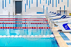 Swimming pool with marked red and white lanes. Empty swimming pool without people with quiet standing water.