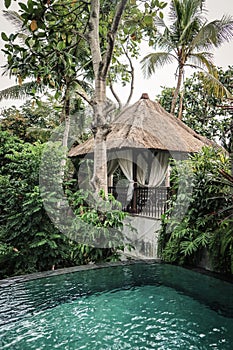 Swimming pool near traditional balinese cozy gazebo