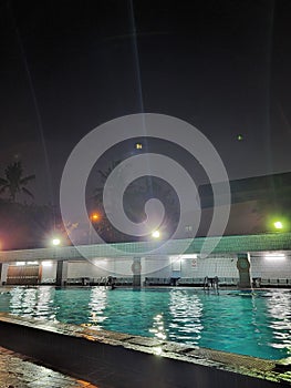 A swimming pool at night with light dark sky