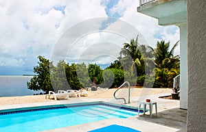 Swimming pool by the ocean with lounge chairs and chiminea