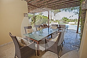 Swimming pool and outdoor dining area at at luxury tropical holiday villa resort