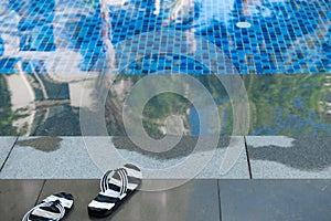 Swimming pool and pair of slippers