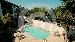 Swimming pool and palm trees, are sitting in a crowd by the pool. territory of the hotel complex.