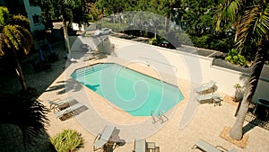 Swimming pool and palm trees, are sitting in a crowd by the pool. territory of the hotel complex. Wide view