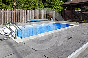 Swimming pool, patio area and barbecue gazebo in backyard of country house