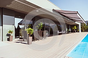 swimming pool and porch of modern country house with little trees chairs