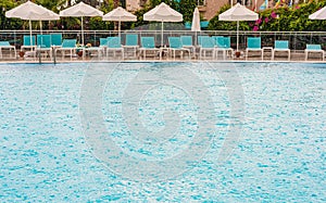 Swimming pool in the rain on a background of sunbeds and umbrellas