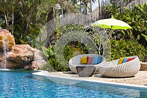 Swimming pool and rattan daybeds in a tropical garden, Thailand
