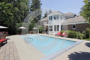 Swimming pool with red lounge chairs