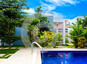 Swimming pool in resort with blue sky background, resort hotel landscaping concept.