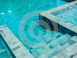 Swimming pool steps with clear water surface background.