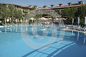 Swimming pool with sunbeds and umbrellas in luxury resort