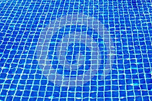 Swimming pool surface texture close up top view, blue water background, caustics ripple, swimming pool tiled bottom backdrop, sea