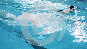 Swimming pool with two butterfly swimmers filmed in slow motion