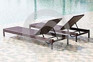 Swimming pool and two deck chairs, close up