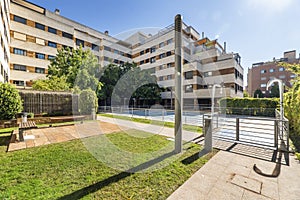 Swimming pool of an urbanization with gardens and grass, showers and trees