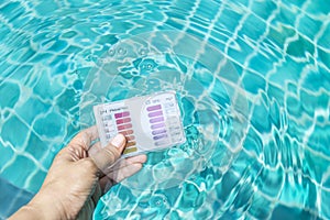 Swimming pool water testing test kit in girl hand