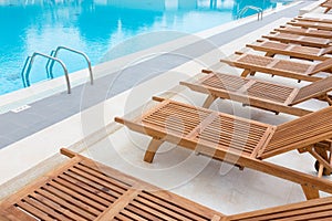 Swimming pool with wooden sunbeds.