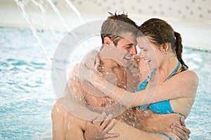 Swimming pool - young loving couple have fun