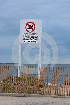 Swimming Prohibited Dangerous Currents warning sign at ocean beach shoreline photo